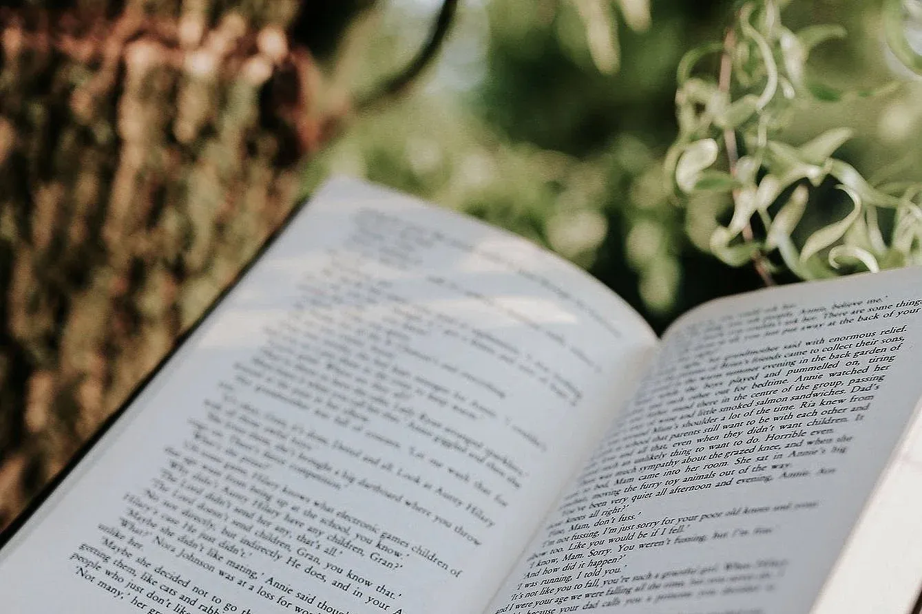 An open book resting against a tree